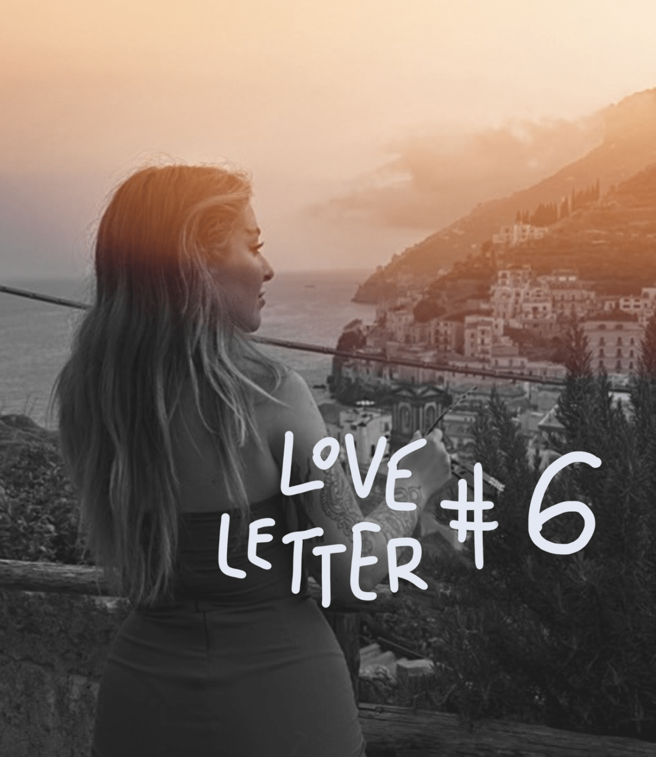 Woman with long hair looking out over a seaside village